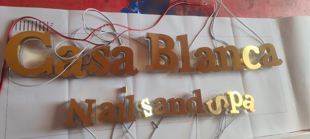 Brushed titanium halo-lit letters glowing at night