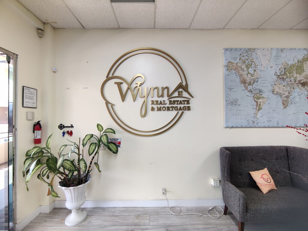 Brushed gold dimensional logo on a real estate office wall