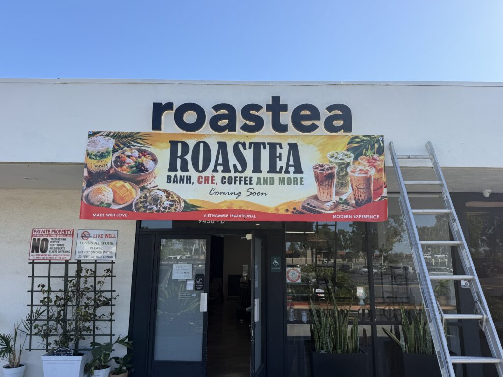 Roastea storefront with channel letters and a grand opening banner